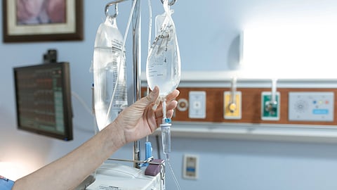Close-up image of an IV drip and hand in a hospital room