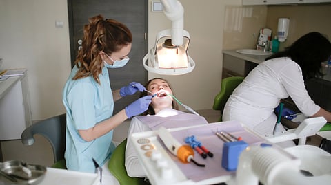 A dentist conducts a dental checkup on a patient in a modern clinic, focusing on oral hygiene