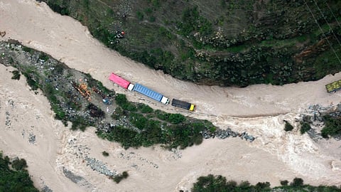 Trucks are stranded on a flooded road on the Central Highway affected by the overflowing Rimac River, in Huarochiri province, Peru