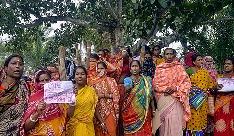 Women holding posters and brooms stage protest in Sandeskhali.