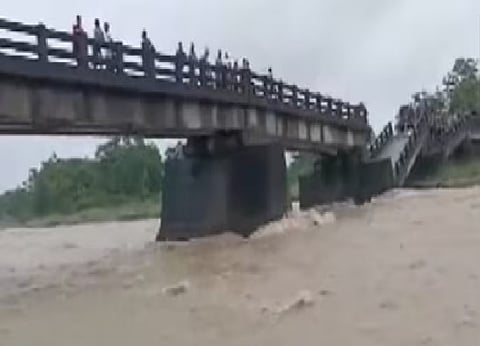 A newly-repaired bridge in Assam's Cachar district collapsed on Wednesday with two overloaded trucks plunging into the Harang river, injuring the drivers, officials said.
