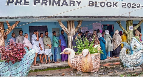 People wait in a queue to cast their votes during the Nilambur Assembly by-election, at GMLP School, in Malappuram district, Kerala, Thursday, June 19, 2025.