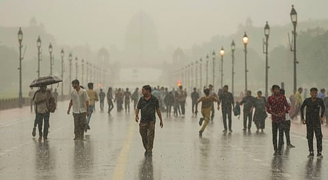 Visitors at the Kartavya Path during rain, in New Delhi, Sunday, June 29, 2025.