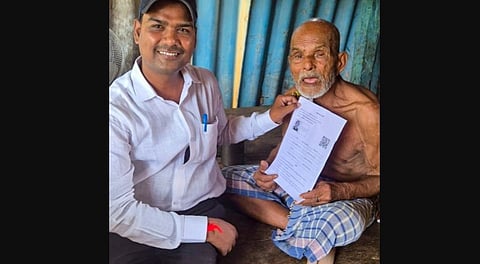 A Booth Level Officer (BLO) hands over an enumeration form to an elderly voter as part of the special intensive revision of electoral rolls, ahead of the Bihar Assembly elections.