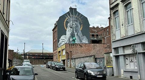 A mural by Dutch artist Judith de Leeuw shows the Statue of Liberty covering her eyes with her hands, in Roubaix, northern France.