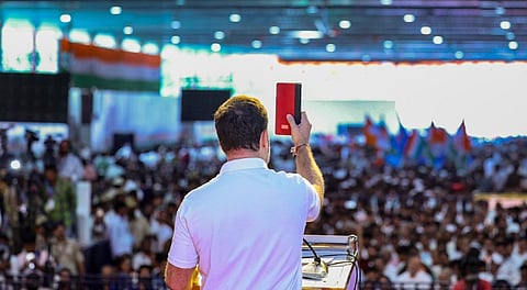 Rahul Gandhi holding a copy of the constitution of India addresses a meeting of party workers .