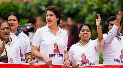 Congress MP Priyanka Gandhi Vadra and other INDIA bloc members seen wearing T-shirts featuring the name Minta Devi, a voter allegedly listed as 124 years old in the Election Commission's voter list, during their protest over the issues of 'poll fraud' and Special Intensive Revision of electoral rolls, at the Monsoon session of Parliament, in New Delhi, Tuesday, Aug. 12, 2025.
