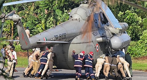 Police and fire personnel try to push President Droupadi Murmu's helicopter after its wheels got stuck on the newly concreted helipad at the Rajiv Gandhi Indoor Stadium, Pramadam, in Pathanamthitta district, Kerala, Wednesday, Oct. 22, 2025.