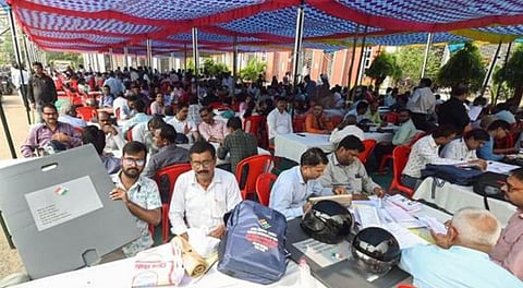 Polling officers check documents at distribution centre before they leave for Bihar assembly election duty, in Patna, on Tuesday. 