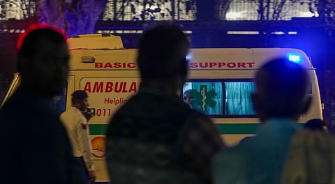 People watch an ambulance that arrives at the LNJP Hospital, where victims of the car blast that occurred near the Red Fort have been admitted, in New Delhi, Monday, Nov. 10, 2025. 