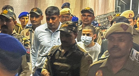 Gangster Anmol Bishnoi, in mask, while being produced in the Patiala House Court, in New Delhi, Wednesday, Nov. 19, 2025.