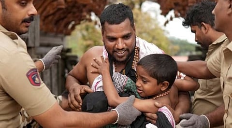 Police personnel placing safety arm band on children in Sabarimala