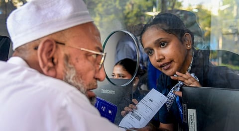 IndiGo airlines staff speaks to a passenger amid flight disruptions, at Chhatrapati Shivaji Maharaj International Airport in Mumbai, Sunday, Dec. 7, 2025.