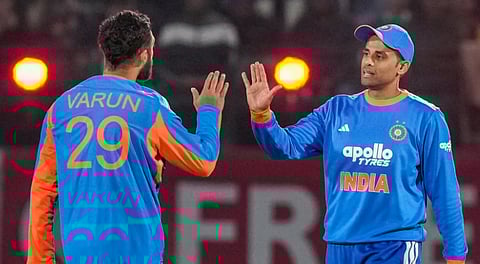 Varun Chakravarthy celebrates with captain Suryakumar Yadav after dismissing South Africa's Donovan Ferreira during the third T20 International between India and South Africa at HPCA Stadium in Dharamshala on December 14, 2025.
