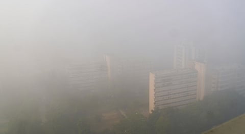 Aerial view of high-rise buildings barely visible through dense fog on a cold winter morning, in New Delhi, Monday, Dec. 15, 2025