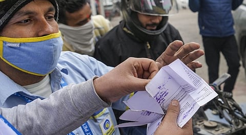 Petrol pump staff checks Pollution Under Control (PUC) documents of commuters at the pollution checking centre of a petrol pump, at Connaught Place, in New Delhi.