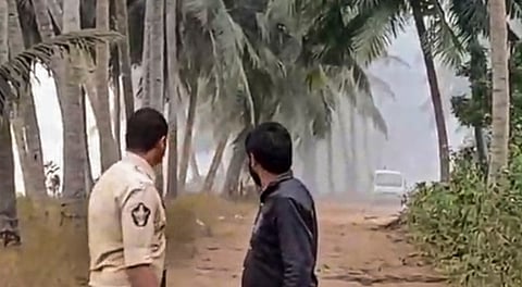 A security personnel, left, near the site after a gas pipeline leak at a well, operated by ONGC�s production contractor Deep Industries Ltd, triggered a fire, in Dr B R Ambedkar Konaseema district, Andhra Pradesh, Monday, Jan. 5, 2026.