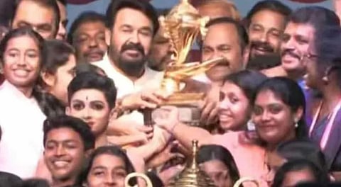Kannur students receive Kalotsavam trophy from actor Mohanlal.