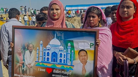 People hold a framed photograph also bearing an image of Suspended TMC MLA Humayun Kabir, who recently floated Janata Unnayan Party (JUP), as construction of a mosque, modelled on Ayodhya's Babri Masjid, begins at Beldanga, in Murshidabad district, West Bengal, Wednesday, Feb. 11, 2026.