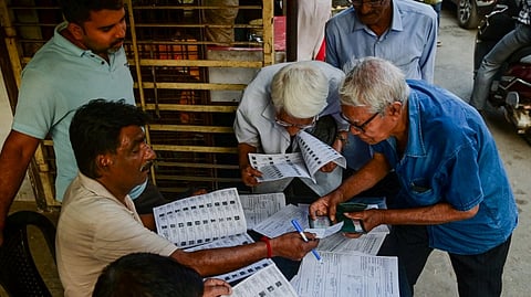 Voters check their names in the list after the Election Commission published West Bengal's post-SIR electoral rolls, in Kolkata, Saturday, Feb. 28, 2026.