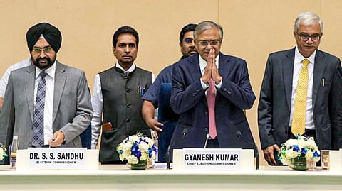 Chief Election Commissioner Gyanesh Kumar, centre front, with Election Commissioners S S Sandhu, left, and Vivek Joshi, right front, during a press conference to announce the Assembly election schedule for West Bengal, Tamil Nadu, Kerala, Assam and Puducherry, at Vigyan Bhawan in New Delhi, Sunday, March 15, 2026.