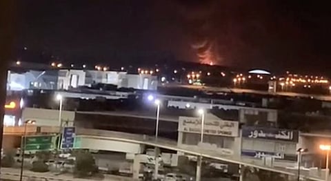 Smoke and flames rise following an Iranian drone strike that hit a fuel tank at Kuwait International Airport.