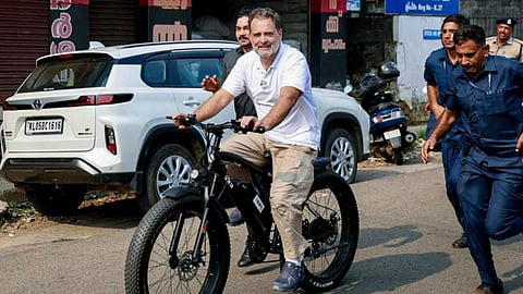 Congress leader Rahul Gandhi rides a bicycle as he campaigns in support of UDF candidate Chandy Oommen.
