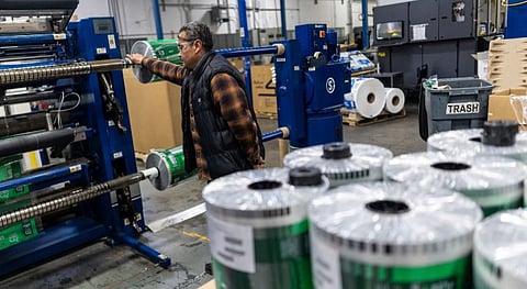 An employee operates a machine that prints plastic bags in California.