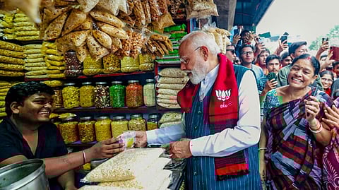 Prime Minister Narendra Modi tries 'jhalmuri', street snack made of puffed rice, on the sidelines of public meetings ahead of the West Bengal Assembly elections, in Jhargram.