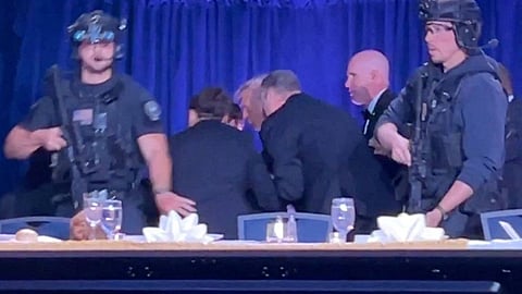 President Donald Trump is escorted out as a shooter opens fire during the annual White House Correspondents' Association dinner in Washington, DC, on Saturday.