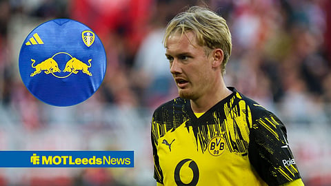 Borussia Dortmund's Julian Brandt in action during a Bundesliga match, looking in the direction of a Leeds United away strip focused on the Red Bull logo.