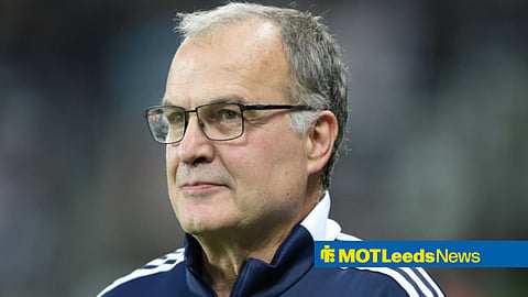 Marcelo Bielsa looking on with slight smile in Leeds United tracksuit