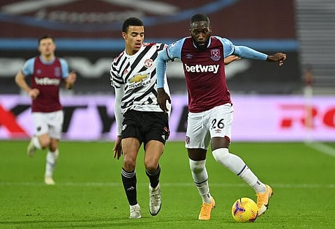 LONDON, ENGLAND - DECEMBER 05: Arthur Masuaku of West Ham United holds off Mason Greenwood of Manchester United during the Premier League match between West Ham United and Manchester United at London Stadium on December 05, 2020 in London, England. A limited number of fans are welcomed back to stadiums to watch elite football across England. This was following easing of restrictions on spectators in tiers one and two areas only. (Photo by Justin Setterfield/Getty Images)