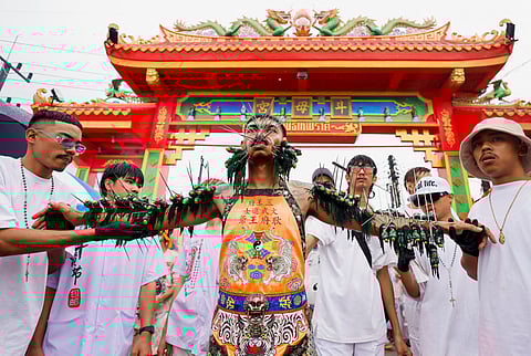 FILE PHOTO: A man with piercings in his mouth and on his arms participate in the Bang Neow Shrine procession during the annual vegetarian festival, observed by Taoist devotees from the Thai-Chinese community in the ninth lunar month of the Chinese calendar, in Phuket, Thailand October 1, 2022. 