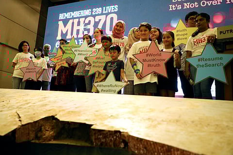 FILE PHOTO: Family members of the victims pose for a group picture with a debris of the missing Malaysia Airlines flight MH370 during its sixth annual remembrance event in Putrajaya, Malaysia, March 7, 2020. 