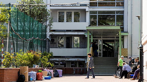 A group of people are gathered in front of the school entrance next to items taken out of the building after Poland seized the Russian embassy school in Warsaw, Poland, April 29, 2023. 