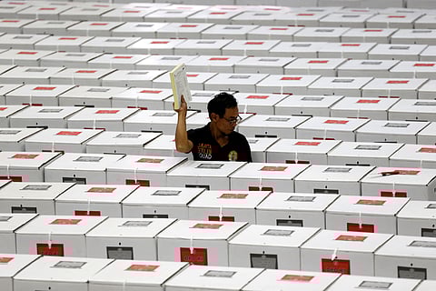 FILE PHOTO: A worker carries election materials as he prepares ballot boxes before their distribution to polling stations in a warehouse in Jakarta, Indonesia, April 15, 2019. 