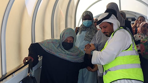 A woman evacuated from Sudan to escape the conflicts is assisted as she arrives in Abu Dhabi airport, United Arab Emirates, April 29, 2023. 