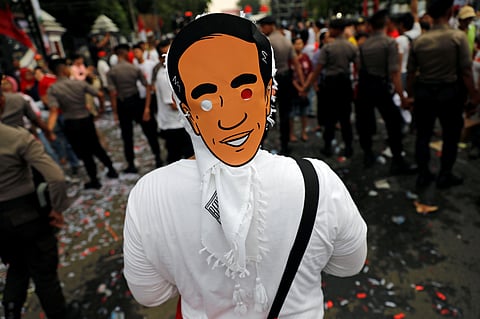FILE PHOTO: A supporter wears a mask of Indonesia's Joko Widodo as he attends a carnival during a campaign rally in Tangerang, Banten province, Indonesia, April 7, 2019. 