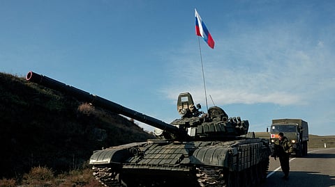 FILE PHOTO: A service member of the Russian peacekeeping troops stands next to a tank near the border with Armenia, following the signing of a deal to end the military conflict between Azerbaijan and ethnic Armenian forces, in the region of Nagorno-Karabakh, November 10, 2020. 