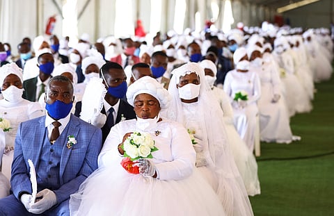 A bride and a groom wait during the Easter Sunday mass wedding ceremony, organised by the International Pentecostal Holiness Church Jerusalem City (IPHC), with more than 800 couples taking part, in Kgabalatsane in the North-West province, South Africa, April 9, 2023. 