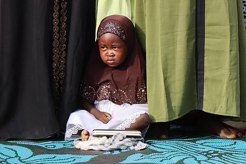 A Muslim girl sits among faithful as they attend Eid al-Fitr prayers, marking the end of the fasting month of Ramadan, in Juba, South Sudan April 21, 2023. 