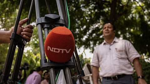 A microphone of New Delhi Television (NDTV) is placed on a tripod along a roadside in New Delhi, India, August 26, 2022. 
