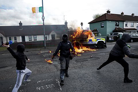 Members of nationalist group 'Dissident Republicans' throw petrol bombs at a police car as nationalists hold an anti-agreement rally on the 25th anniversary of the peace deal, in Londonderry, Northern Ireland, April 10, 2023. 