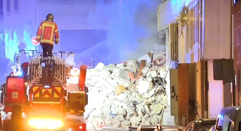 A firefighter stands on a fire truck after a building collapsed in Marseille, France, April 9, 2023, in this screengrab obtained from a social media video. 
