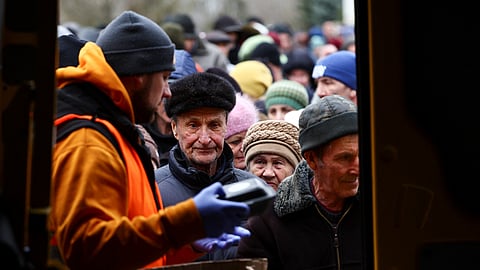 FILE PHOTO-People receive meals from World Central Kitchen food truck on a street in Kherson, Ukraine February 22, 2023. 