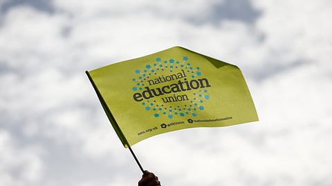 FILE PHOTO-A National Education Union flag is held aloft as teachers join the strike action in Luton, Britain February 1, 2023. 