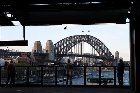 People stand at a train platform near the Sydney Harbour Bridge in Sydney, Australia, November 11, 2020. 