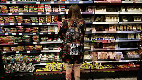FILE PHOTO: A person wearing a backpack looks at food goods in a shop as UK inflation heads towards 10% in London, Britain, June 16, 2022. 