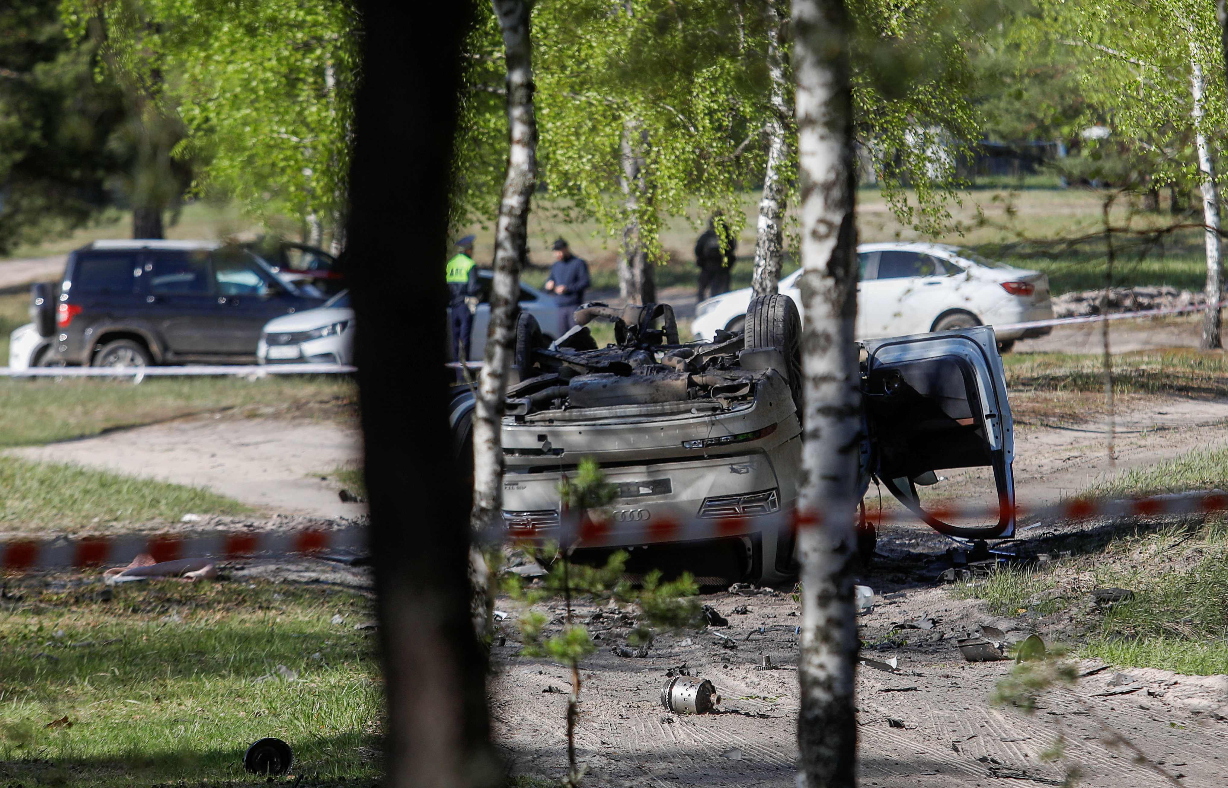 A view shows a damaged white Audi Q7 car lying overturned on a track next to a wood, after Russian nationalist writer Zakhar Prilepin was allegedly wounded in a bomb attack in a village in the Nizhny Novgorod region, Russia, May 6, 2023. 